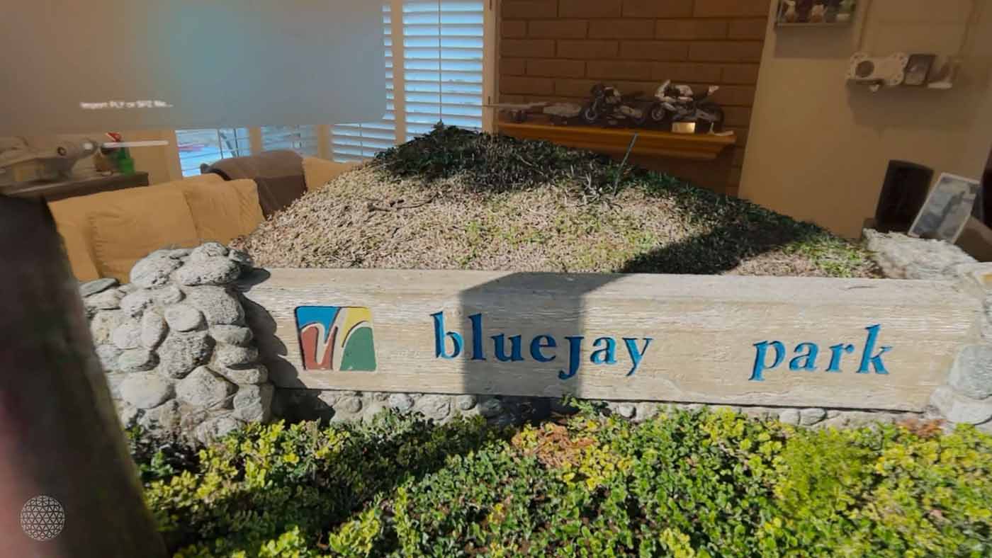 A gaussian splat of a park showing a sign with Bluejay Park written on it